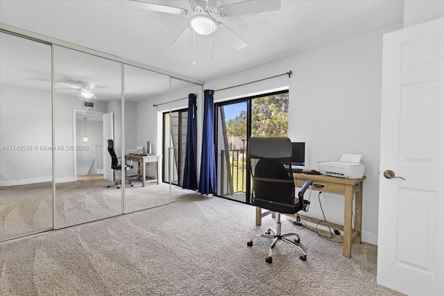 carpeted home office with baseboards, visible vents, a ceiling fan, and a textured ceiling