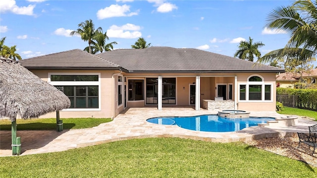 back of property featuring a tile roof, stucco siding, a pool with connected hot tub, a lawn, and a patio area