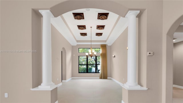 hall featuring decorative columns, baseboards, and a raised ceiling