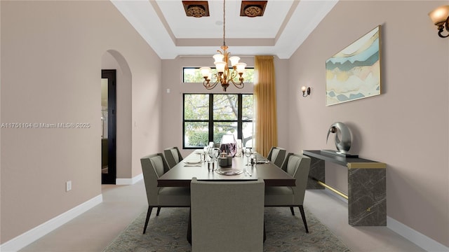 dining area featuring arched walkways, a tray ceiling, an inviting chandelier, and baseboards