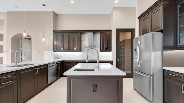 kitchen with stainless steel appliances, light countertops, a sink, and hanging light fixtures