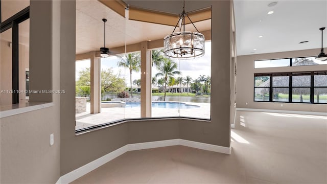 unfurnished dining area featuring a water view, a ceiling fan, and baseboards