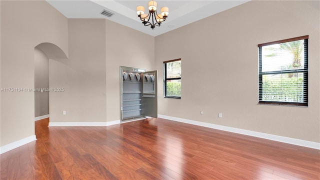 spare room featuring wood finished floors, visible vents, and baseboards