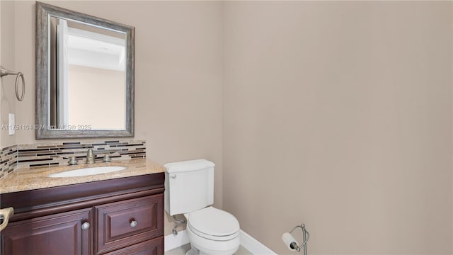 half bathroom featuring toilet, tasteful backsplash, baseboards, and vanity