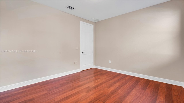 unfurnished room with visible vents, baseboards, and wood finished floors