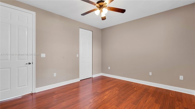 unfurnished room with wood finished floors, a ceiling fan, and baseboards