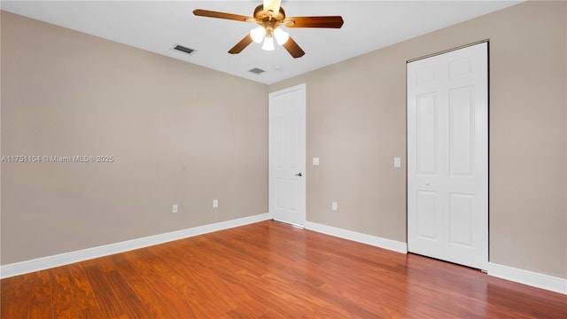 unfurnished bedroom with visible vents, ceiling fan, baseboards, and wood finished floors