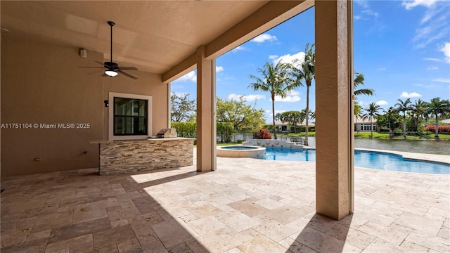 view of patio featuring a pool with connected hot tub, area for grilling, outdoor wet bar, and a ceiling fan