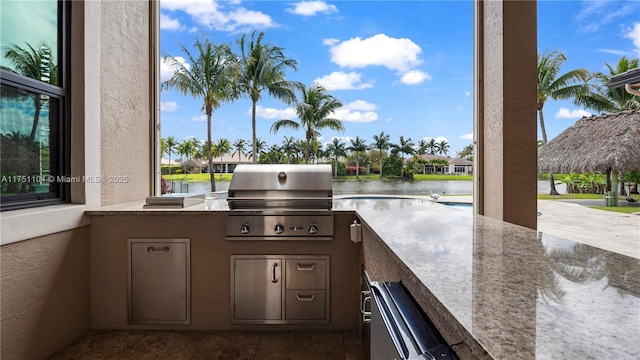 view of patio / terrace featuring area for grilling, grilling area, and a water view