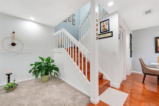staircase featuring recessed lighting, wood finished floors, visible vents, and baseboards
