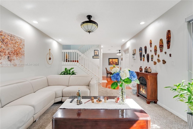 living area featuring recessed lighting, light carpet, stairway, and baseboards