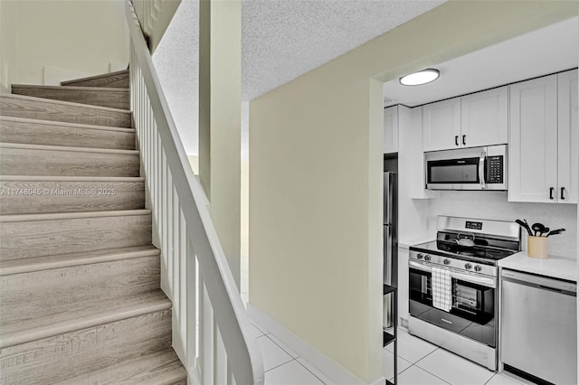 stairway featuring tile patterned flooring and a textured ceiling