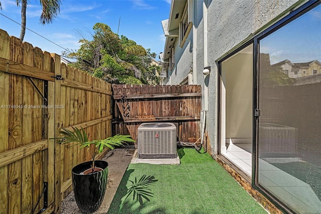 view of yard with fence and central air condition unit