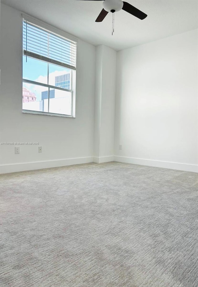 spare room featuring ceiling fan, carpet floors, and baseboards