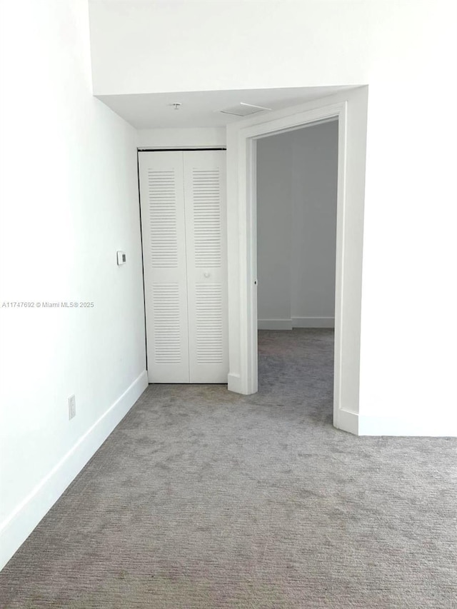 unfurnished bedroom featuring light carpet, baseboards, and a closet