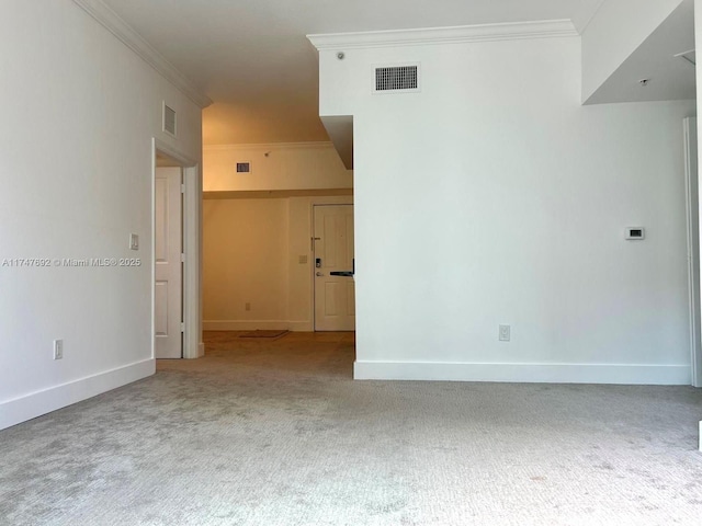 spare room featuring light carpet, baseboards, visible vents, and crown molding