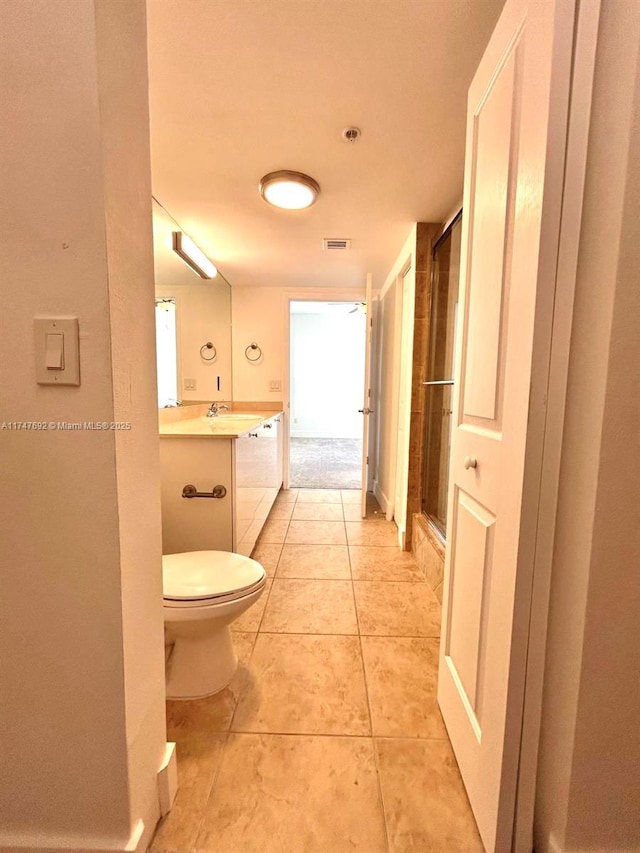 bathroom with toilet, tile patterned flooring, a closet, and vanity