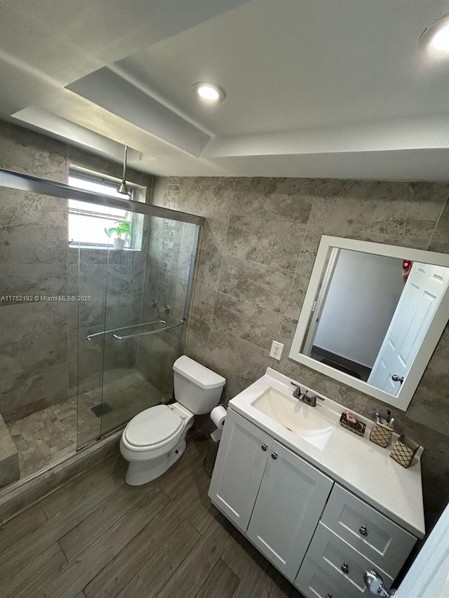 16900 NE 14th Ave Unit 209, Miami, FL 33162 - full bathroom with tile walls, toilet, vanity, a stall shower, and wood finished floors