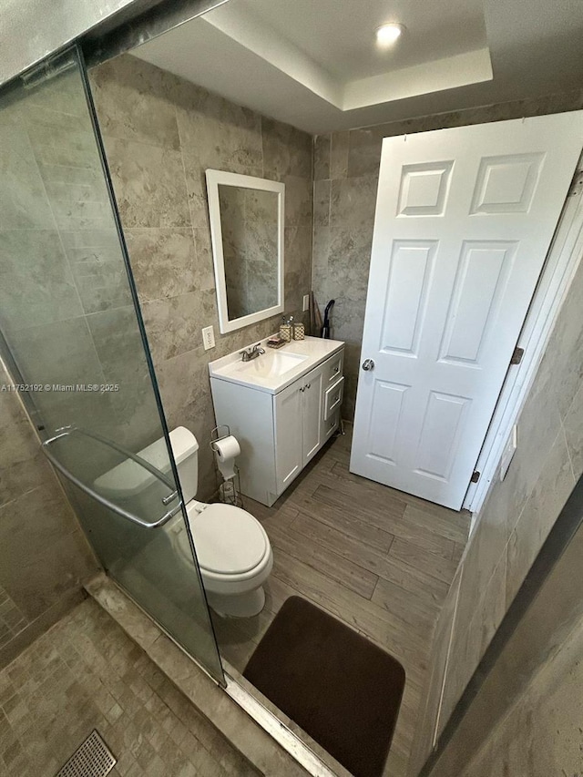 16900 NE 14th Ave Unit 209, Miami, FL 33162 - full bath featuring toilet, vanity, tile walls, a tray ceiling, and wood finished floors