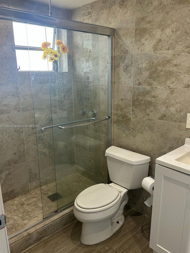16900 NE 14th Ave Unit 209, Miami, FL 33162 - bathroom with toilet, wood finished floors, vanity, a shower stall, and tile walls