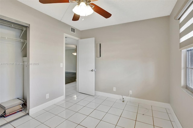 unfurnished bedroom with a ceiling fan, visible vents, baseboards, and light tile patterned flooring