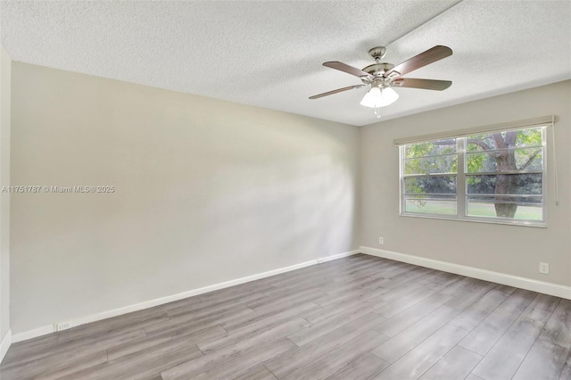 empty room featuring light wood-style flooring, a textured ceiling, baseboards, and a ceiling fan