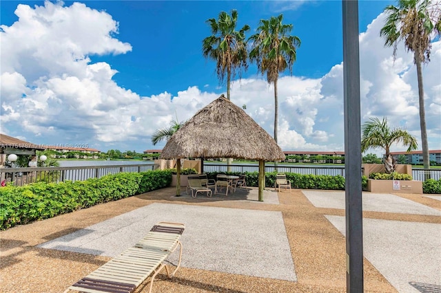 view of patio featuring a water view, fence, and a gazebo