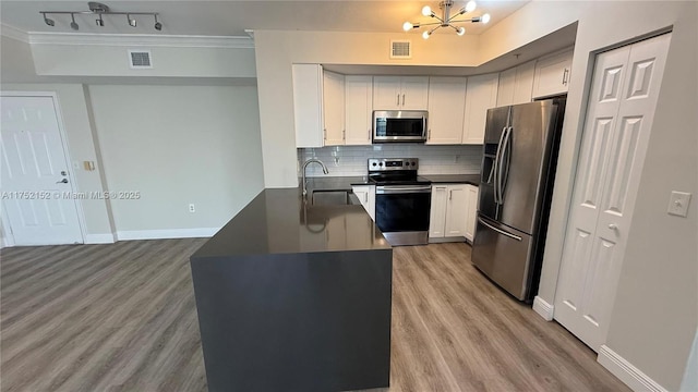 kitchen featuring visible vents, appliances with stainless steel finishes, dark countertops, and white cabinetry