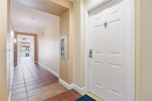 interior space with baseboards and light tile patterned flooring