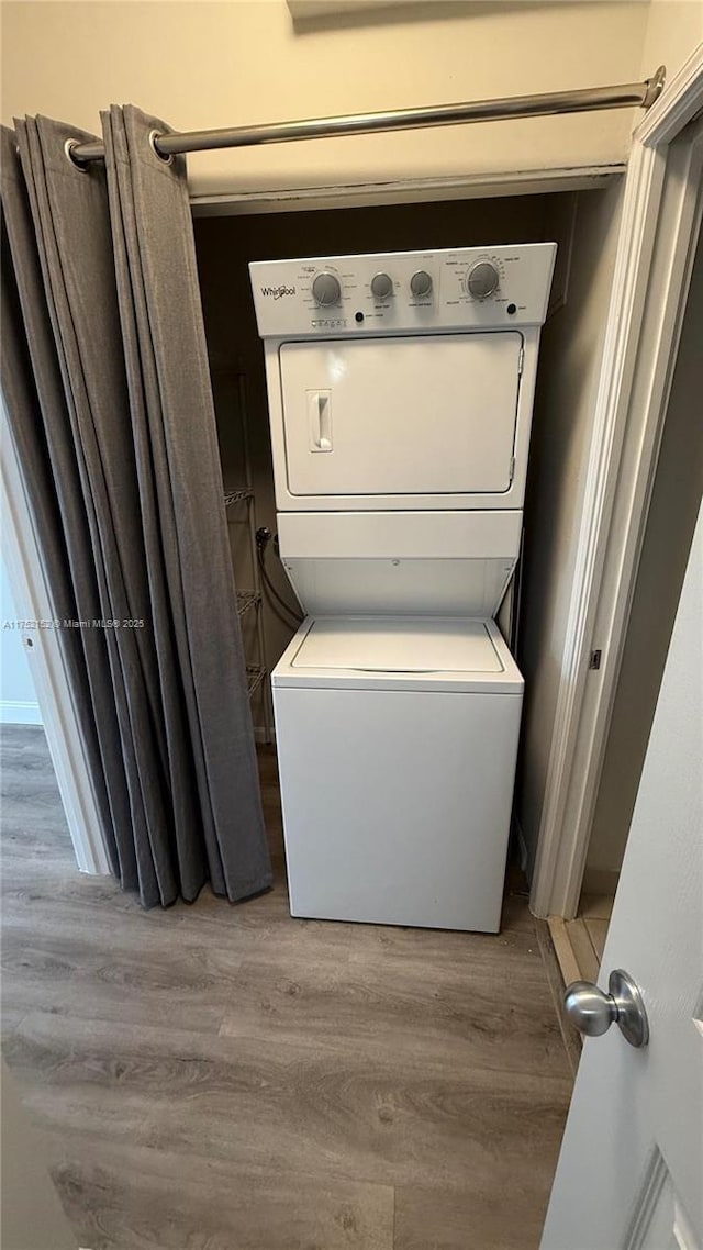 laundry room with laundry area, light wood finished floors, and stacked washing maching and dryer