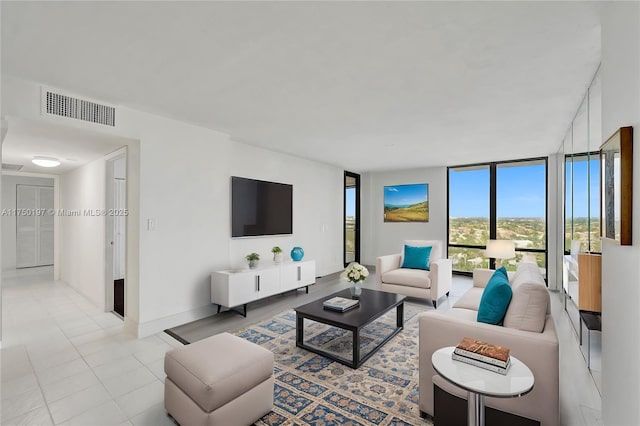 living room featuring light tile patterned floors, baseboards, expansive windows, and visible vents