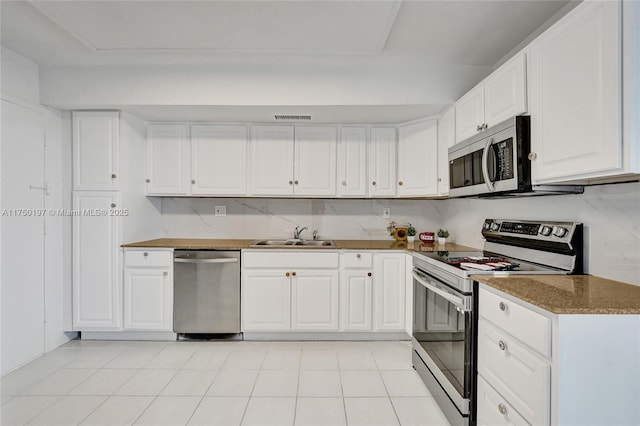 kitchen featuring appliances with stainless steel finishes, a sink, visible vents, and white cabinets