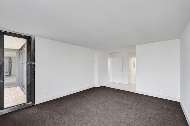 unfurnished room featuring carpet and baseboards