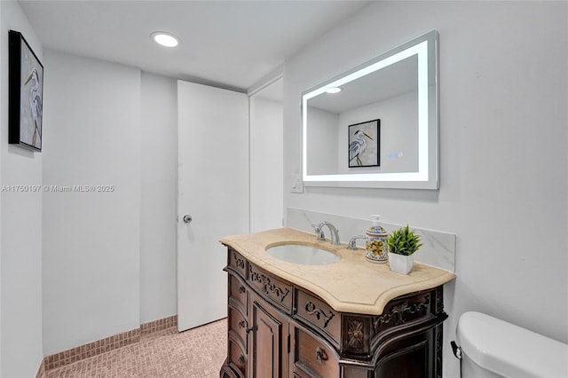 half bath featuring recessed lighting, vanity, and toilet