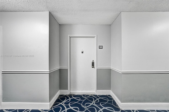 interior space with baseboards and a textured ceiling