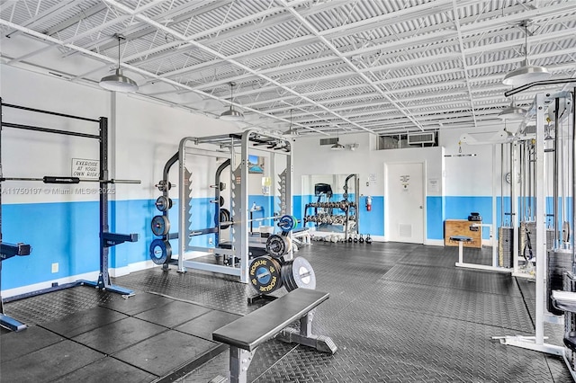 exercise room featuring a garage, visible vents, and baseboards