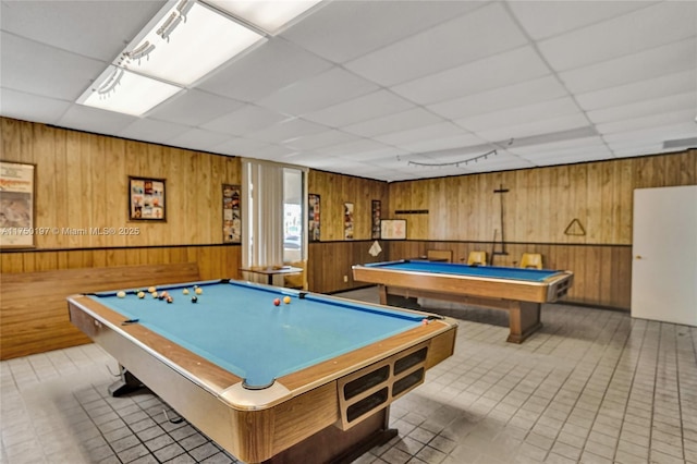 game room featuring billiards, a paneled ceiling, and wooden walls