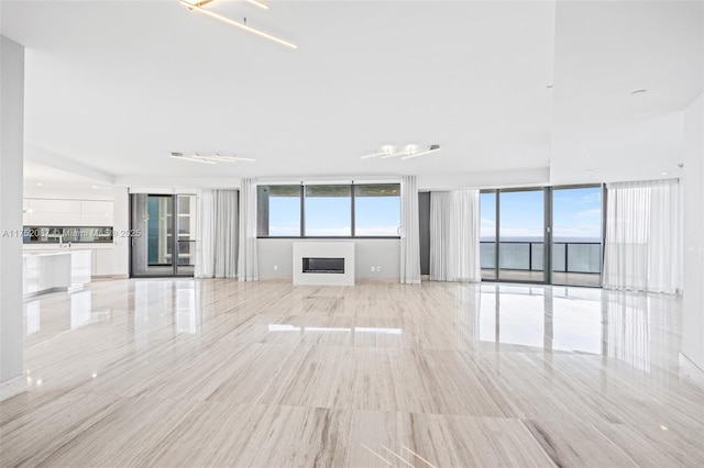 unfurnished living room featuring a water view and a fireplace