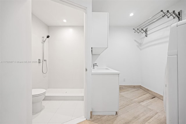 bathroom with recessed lighting, toilet, a stall shower, vanity, and baseboards