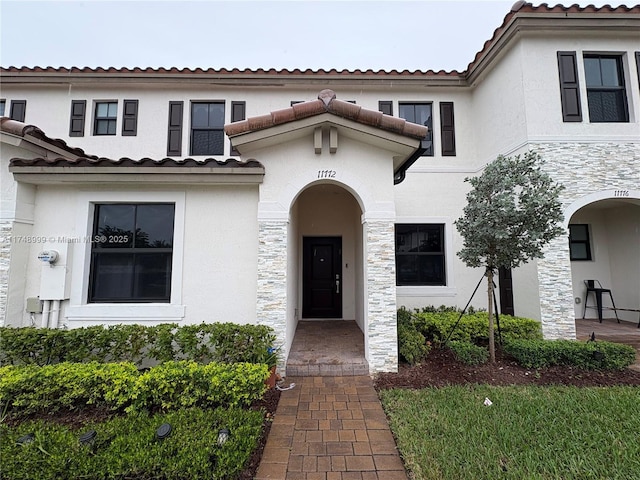 exterior space with a tiled roof and stucco siding