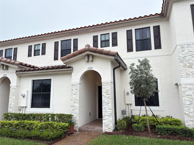 mediterranean / spanish-style home with stone siding and stucco siding