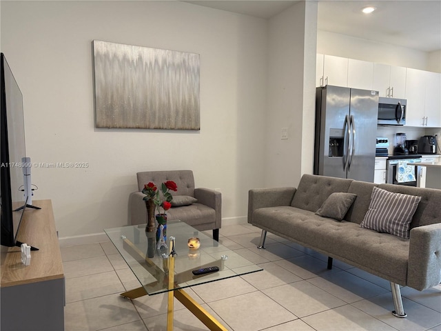 living area featuring light tile patterned floors and baseboards