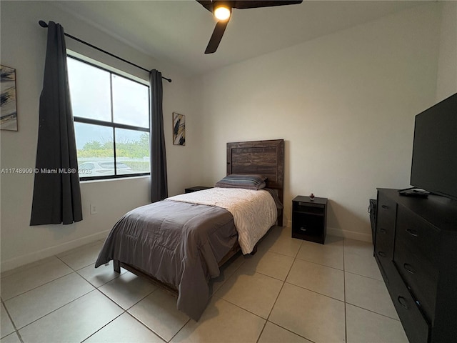 bedroom featuring baseboards, a ceiling fan, and light tile patterned flooring