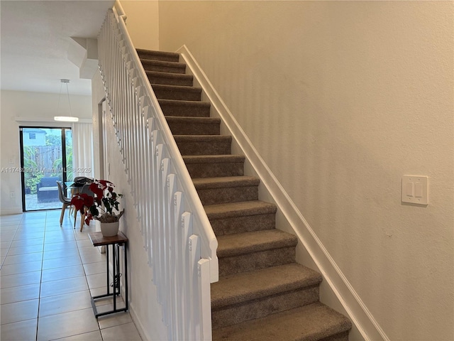 stairs featuring tile patterned flooring and baseboards