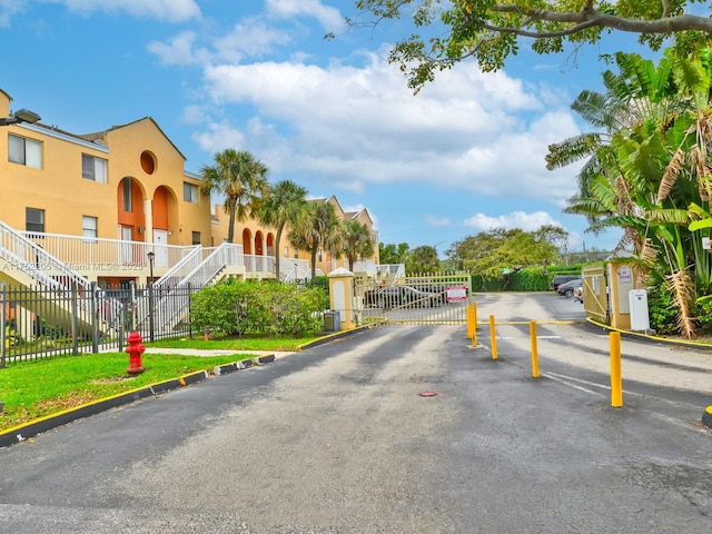 view of street with curbs, a gated entry, a residential view, and a gate