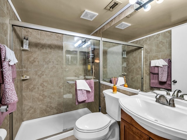 bathroom with visible vents, a stall shower, vanity, and toilet