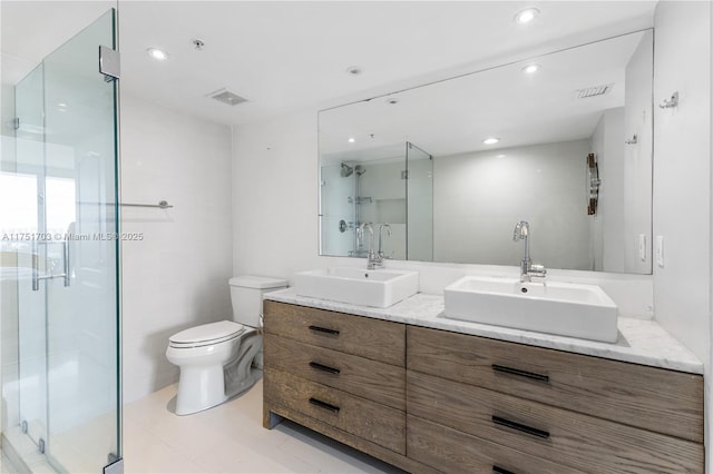 bathroom featuring toilet, a sink, and visible vents