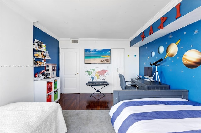 bedroom featuring visible vents, an accent wall, ornamental molding, wood finished floors, and wallpapered walls