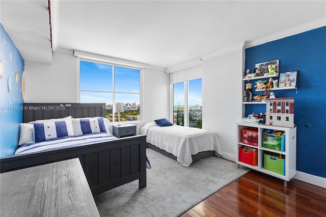 bedroom with crown molding, baseboards, and dark wood-type flooring