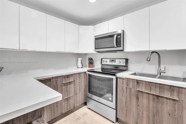 kitchen with appliances with stainless steel finishes, light countertops, and modern cabinets